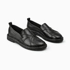 Mocassin femme cuir de vache noir posé sur fond blanc uni