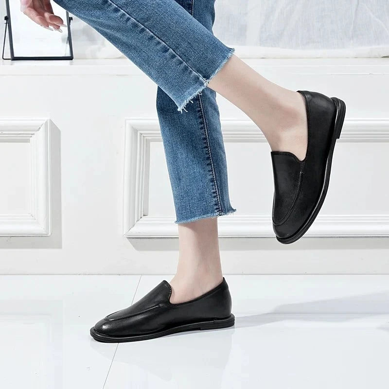 mocassins noirs portés avec une jambe légèrement relevée