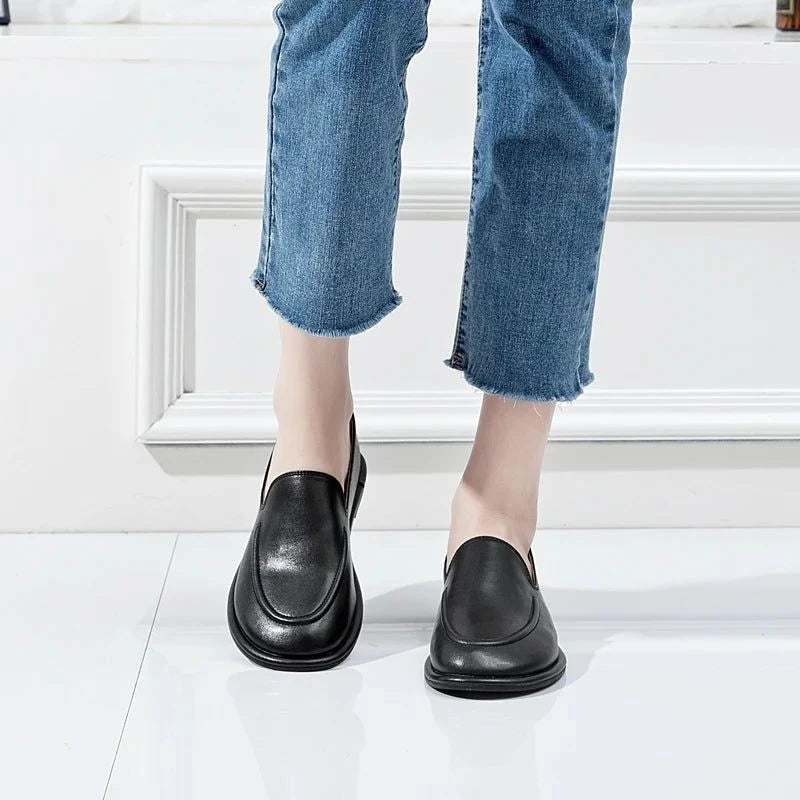 paire de mocassins noirs portée avec un jean vu de face