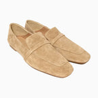 Mocassins en daim beige clair tournés de trois quarts sur fond blanc