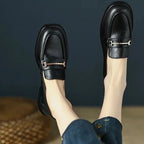 paire de mocassins noirs portés, jambes relevées et pieds joints