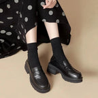 La paire portée en position assise, jupe noire à pois et chaussettes visibles