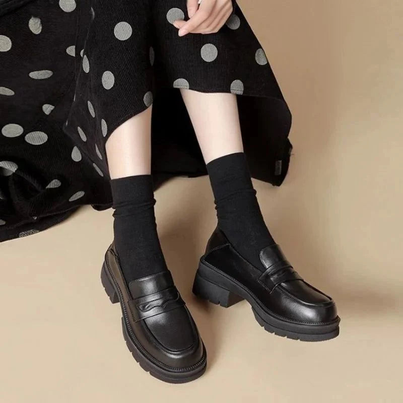 La paire portée en position assise, jupe noire à pois et chaussettes visibles