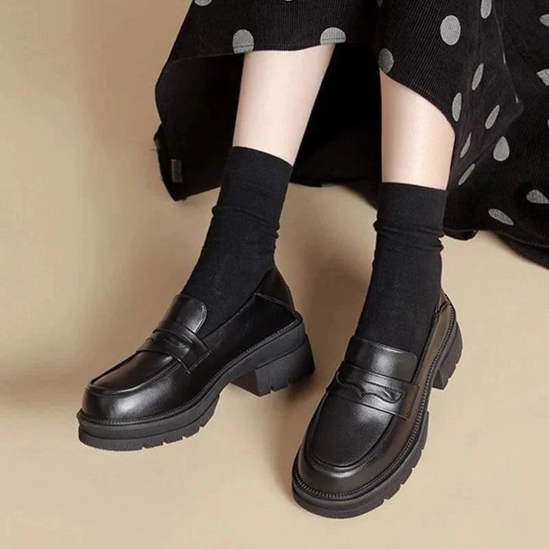 Gros plan sur les mocassins noirs portés, vue de dessus avec jambes croisées