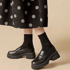 Mocassins noirs portés avec jupe à pois et chaussettes montantes noires