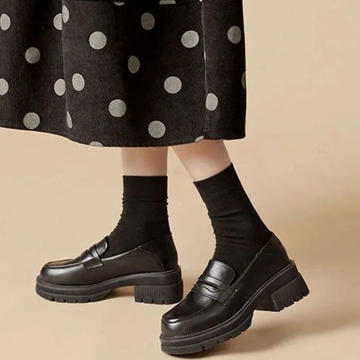 Mocassins noirs portés avec jupe à pois et chaussettes montantes noires