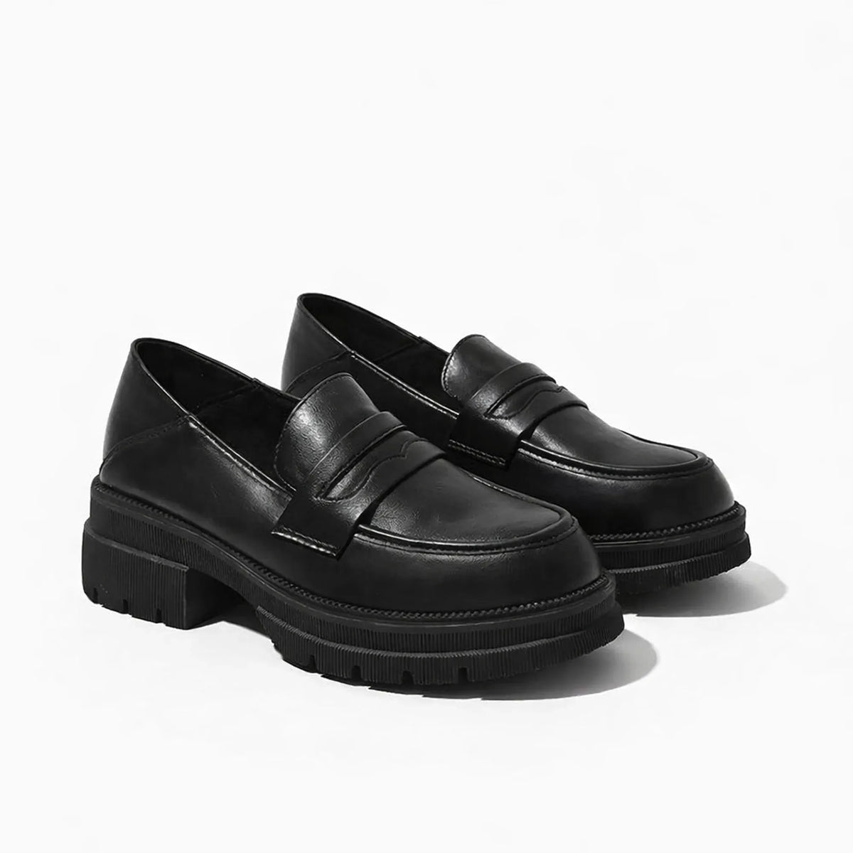 Mocassin femme semelle épaisse noir posé sur fond uni clair