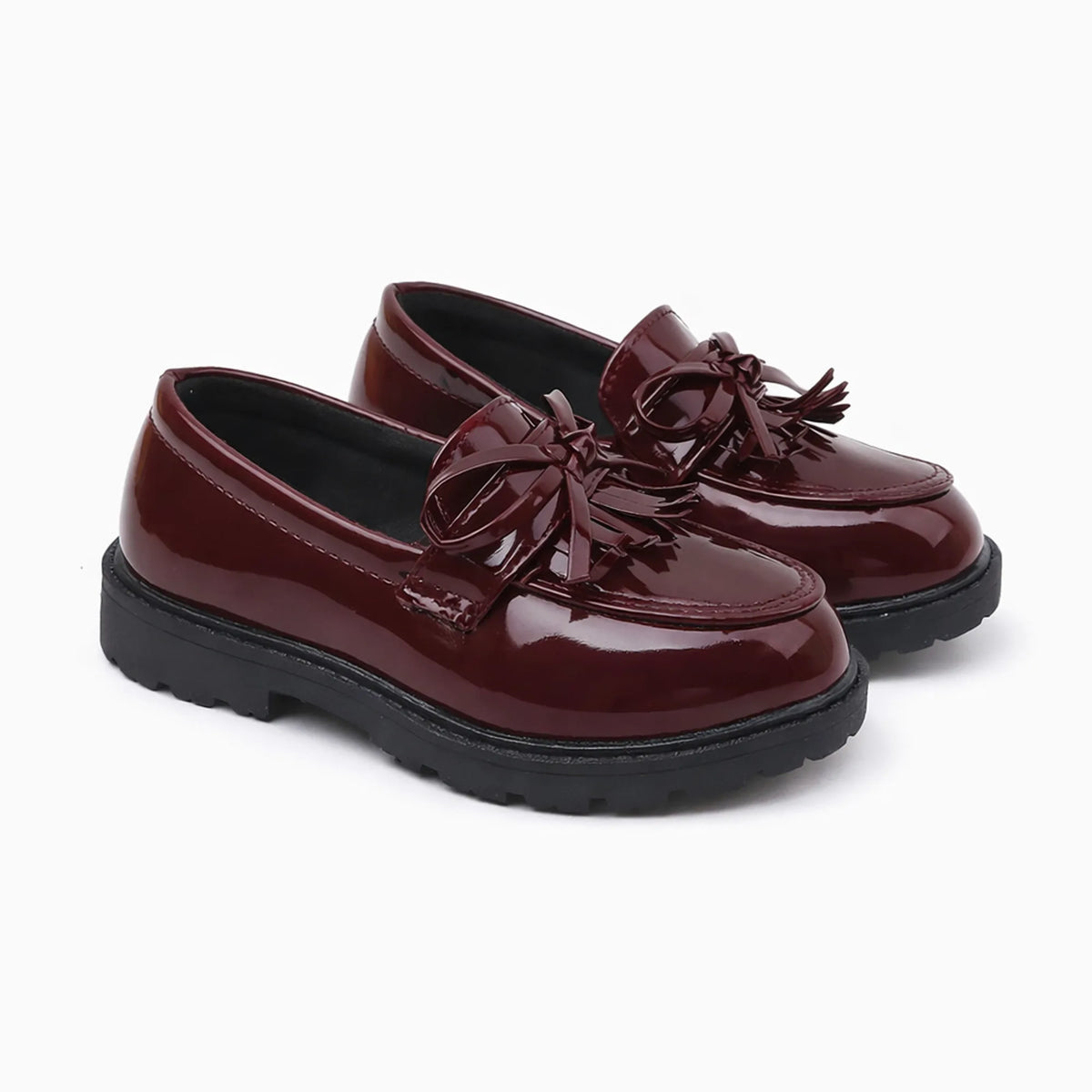 paire de mocassins avec nœud et glands coloris bordeaux sur fond uni
