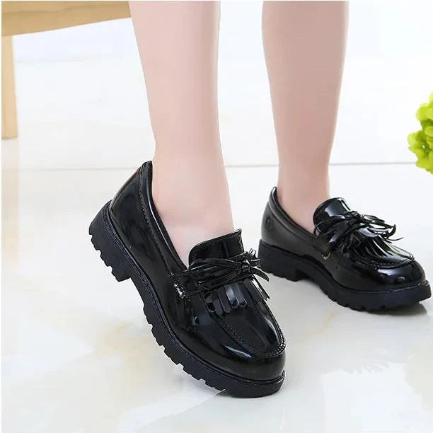 mocassins noirs portés vue de côté sur pied d'enfant