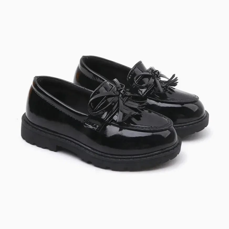 Mocassin fillette à nœud et glands noir, posé sur fond blanc