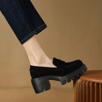gros plan sur le mocassin noir porté de profil sur un tabouret