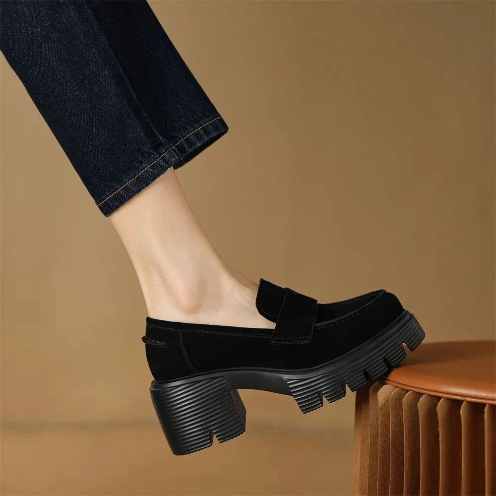 gros plan sur le mocassin noir porté de profil sur un tabouret