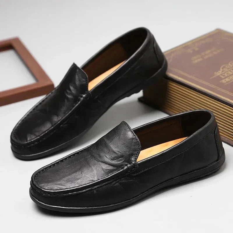 Mocassins noirs posés près de livres sur une table claire