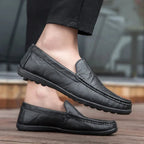 Mocassins noirs en cuir portés avec un pantalon sombre sur une terrasse