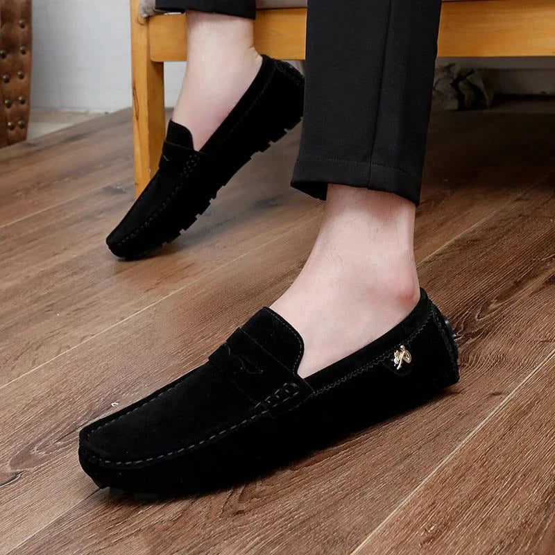 mocassins noirs portés, pieds posés au sol près d’un banc