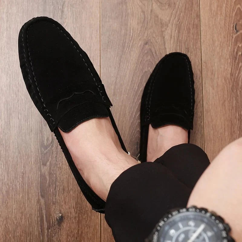 paire de mocassins noirs portée avec un pantalon sombre, vue du dessus