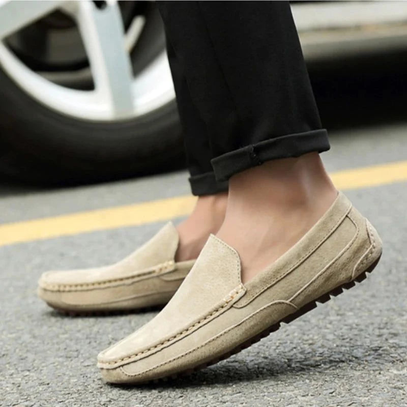 Mocassins en daim kaki portés avec un pantalon noir à l'extérieur
