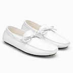 paire de mocassins blancs posée côte à côte sur fond uni