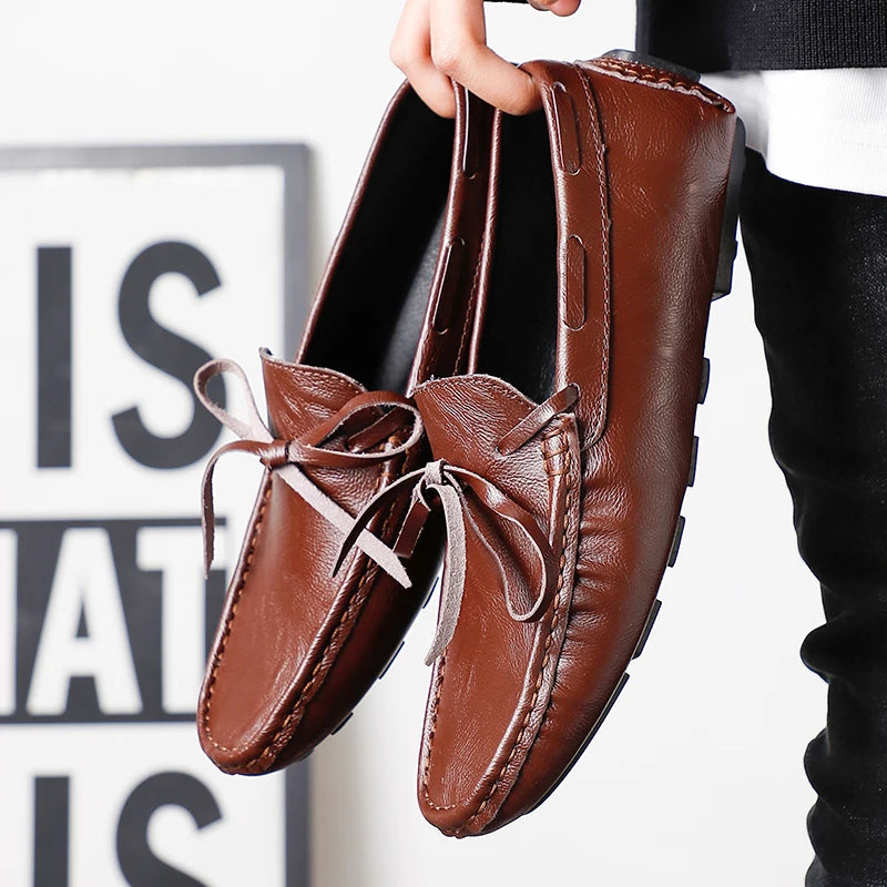 Paire de mocassins homme à lacet en cuir marron foncé tenue à la main