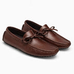 paire de mocassins marron foncé posée côte à côte sur fond uni