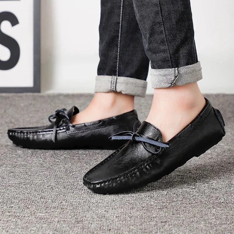 paire de mocassins noirs portée, vue latérale sur sol intérieur