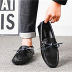 personne enfilant un mocassin noir avec une main, vue en situation