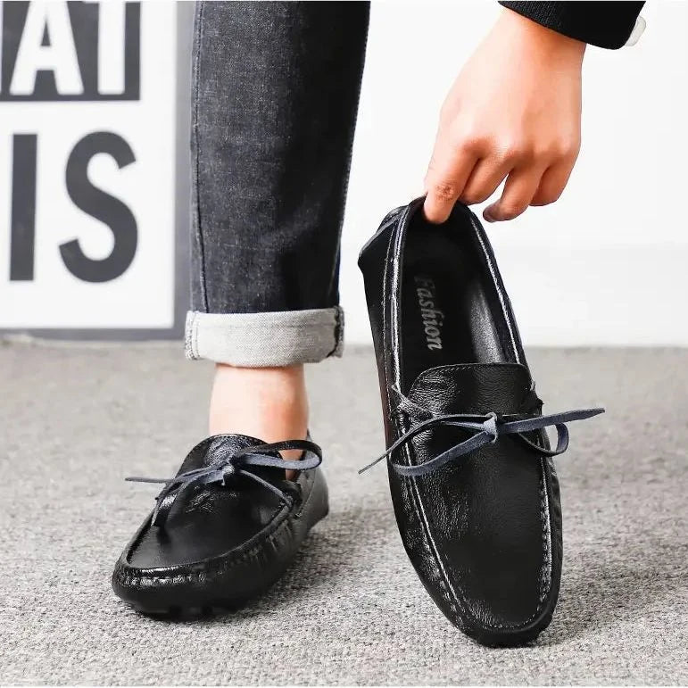 personne enfilant un mocassin noir avec une main, vue en situation