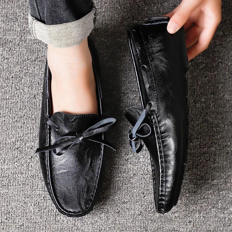 mocassin noir porté vue de dessus avec une main tenant le talon