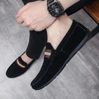 mocassin noir porté avec un pantalon sombre et une montre au poignet