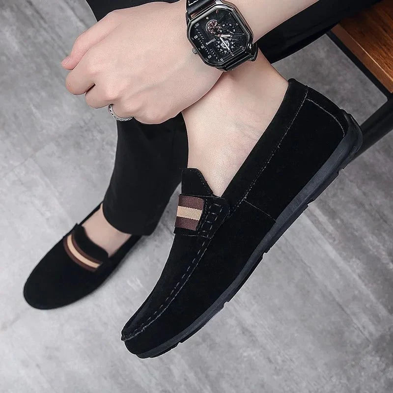 mocassin noir porté avec un pantalon sombre et une montre au poignet