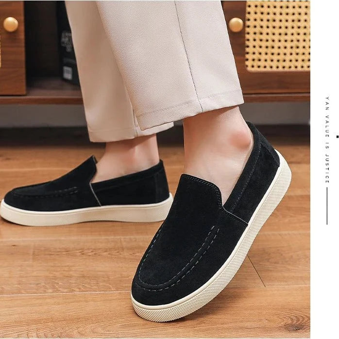 paire de mocassins noirs à semelle blanche portée avec un pantalon beige