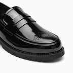 Détail du bout perforé et de la semelle épaisse du mocassin homme vernis noir