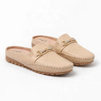 paire de mules ton beige clair avec détail chaîne dorée posée sur fond uni