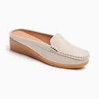 Chaussure mule ajourée en cuir beige posée sur fond blanc