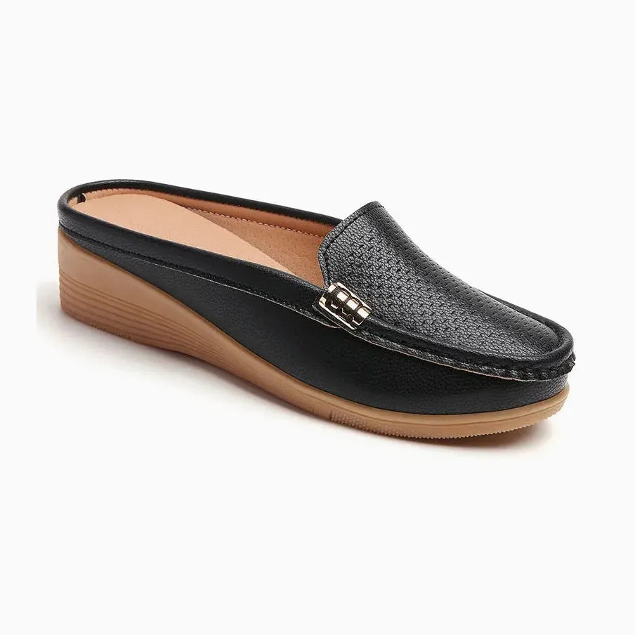 Mocassin mule femme ajouré en cuir noir présenté sur fond uni