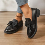 mocassins noirs portés debout vue de côté sur parquet