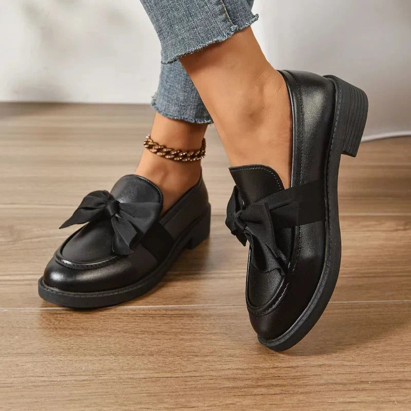 mocassins noirs portés debout vue de côté sur parquet