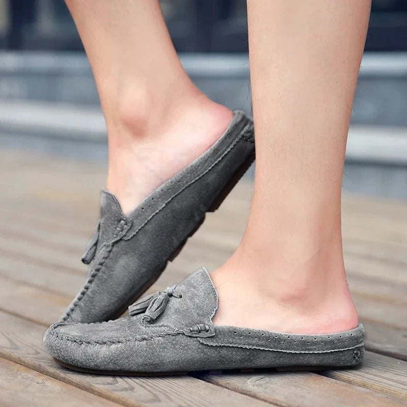 Mocassins ouverts gris portés de profil, pieds légèrement surélevés