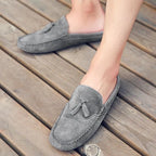 Mocassins gris portés avec une tenue estivale sur un sol en bois