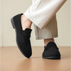 vue arrière du mocassin noir porté en mouvement avec un pantalon clair