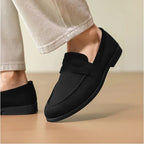 mocassin noir porté vu de trois quarts avec un pantalon écru