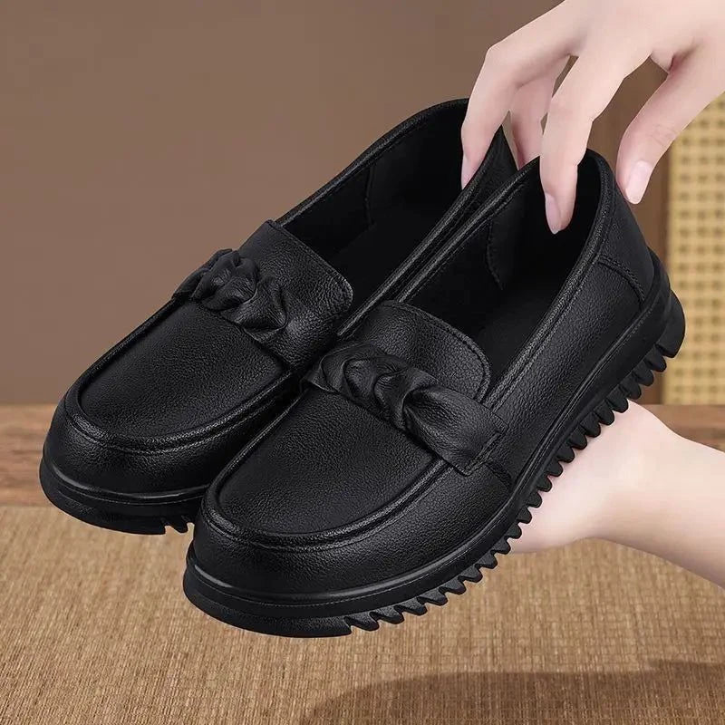 paire de mocassins noirs tenue à la main montrant la souplesse et la légèreté