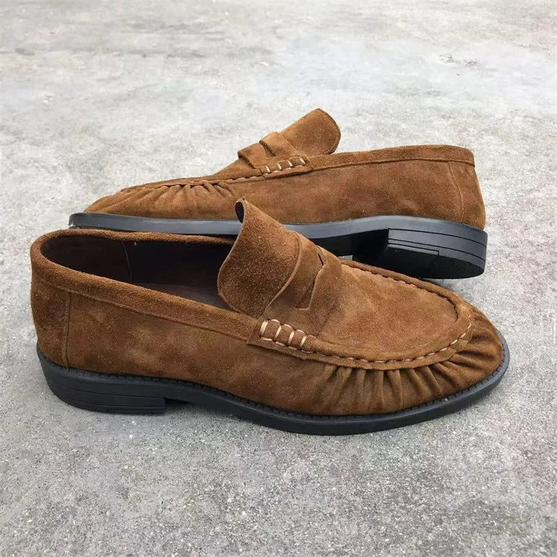 Paire de mocassins camel vue de l’arrière sur sol brut