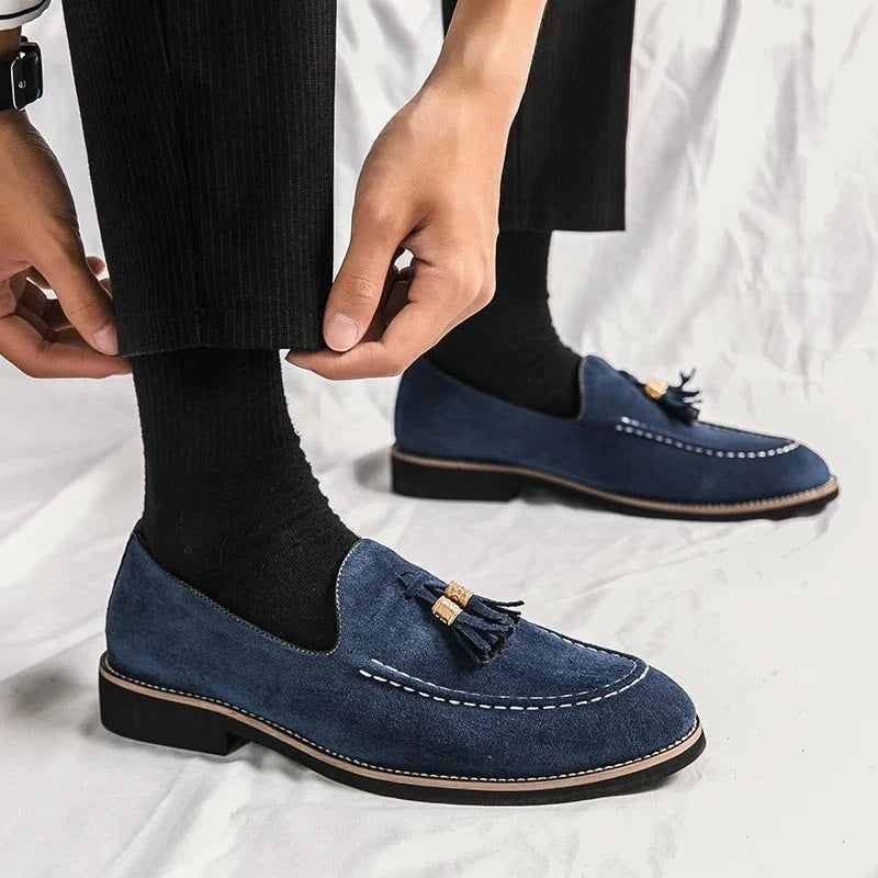 paire de mocassins bleus portée avec un pantalon noir et des chaussettes noires