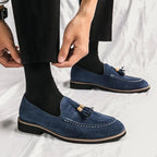 paire de mocassins bleus portée avec un pantalon noir et des chaussettes noires