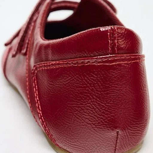 Zoom sur l’arrière d’un mocassin vernis rouge avec surpiqûres visibles