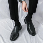 mocassins vernis noirs portés debout avec un pantalon, vue de dessus