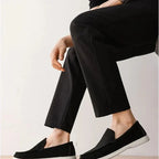 mocassins noirs portés avec un pantalon sombre, personne assise