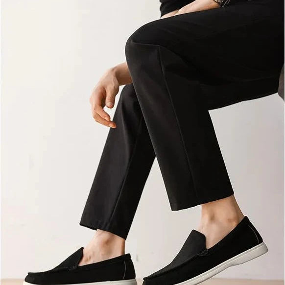 mocassins noirs portés avec un pantalon sombre, personne assise