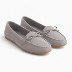 paire de mocassins gris clair vue de trois quarts sur fond neutre